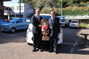 寄贈された公用車の前で市長と山崎様と記念撮影の様子です